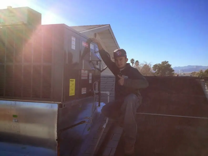 HVAC technician performing AC Tune-Up on a rooftop unit in Westlake